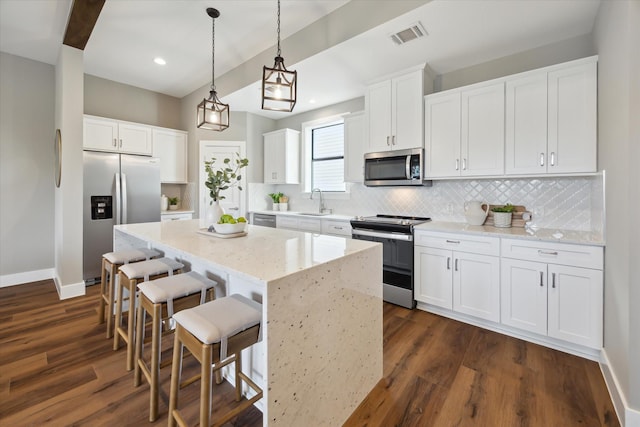 3104 Eunice St, Houston, TX 77009 - kitchen featuring stainless steel appliances, a sink, a center island, tasteful backsplash, and baseboards