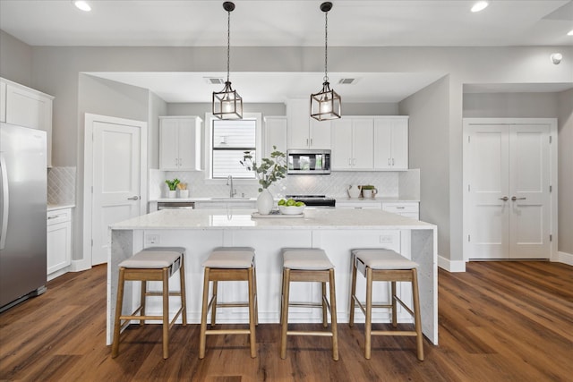 3104 Eunice St, Houston, TX 77009 - kitchen with appliances with stainless steel finishes, a sink, a breakfast bar area, dark wood-style flooring, and backsplash