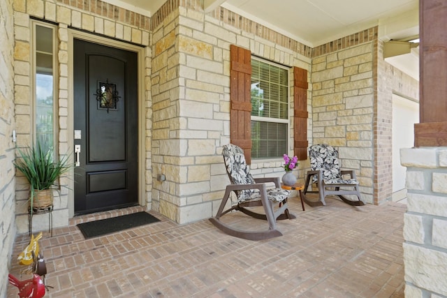 23440 Yaupon Hills Dr, New Caney, TX 77357 - view of exterior entry with covered porch, stone siding, and brick siding