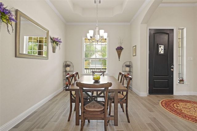 23440 Yaupon Hills Dr, New Caney, TX 77357 - dining area featuring light wood-style flooring, a raised ceiling, a chandelier, and baseboards