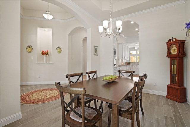 23440 Yaupon Hills Dr, New Caney, TX 77357 - dining space with arched walkways, light wood-style flooring, baseboards, crown molding, and a raised ceiling