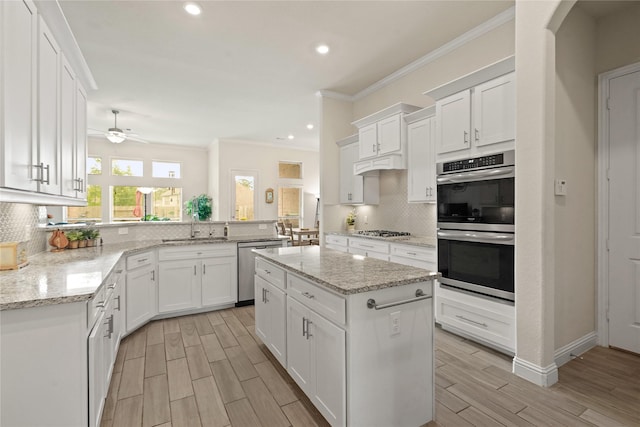 23440 Yaupon Hills Dr, New Caney, TX 77357 - kitchen with stainless steel appliances, a sink, tasteful backsplash, crown molding, and a peninsula