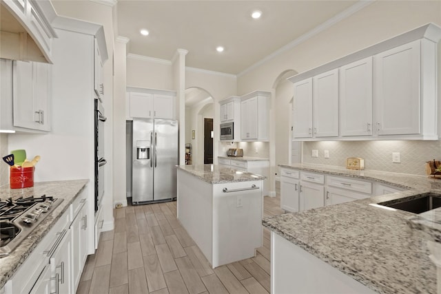 23440 Yaupon Hills Dr, New Caney, TX 77357 - kitchen with stainless steel appliances, ornamental molding, white cabinets, light wood finished floors, and recessed lighting