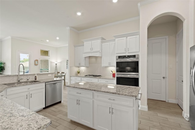 23440 Yaupon Hills Dr, New Caney, TX 77357 - kitchen with appliances with stainless steel finishes, a sink, tasteful backsplash, wood finish floors, and recessed lighting