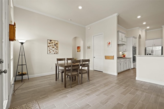 23440 Yaupon Hills Dr, New Caney, TX 77357 - dining area featuring arched walkways, ornamental molding, recessed lighting, baseboards, and light wood-style floors