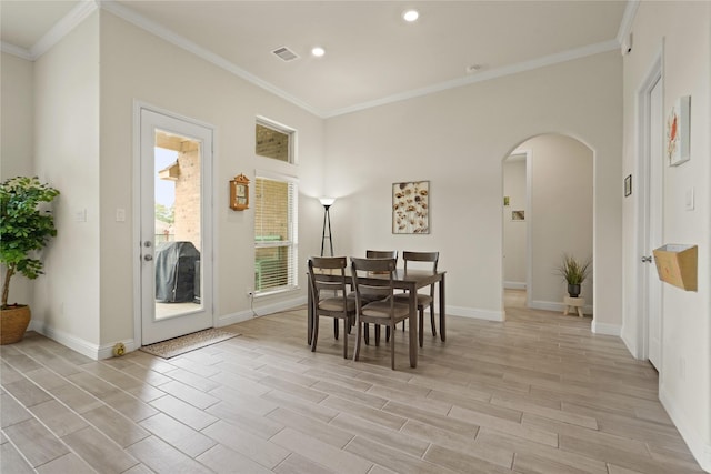 23440 Yaupon Hills Dr, New Caney, TX 77357 - dining area featuring arched walkways, baseboards, light wood finished floors, ornamental molding, and recessed lighting
