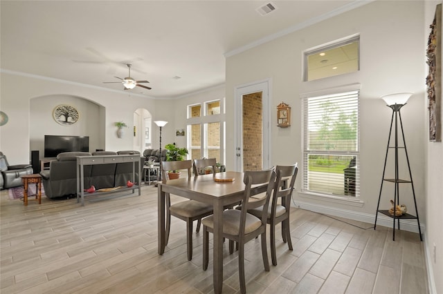 23440 Yaupon Hills Dr, New Caney, TX 77357 - dining space with arched walkways, light wood-type flooring, plenty of natural light, and ornamental molding