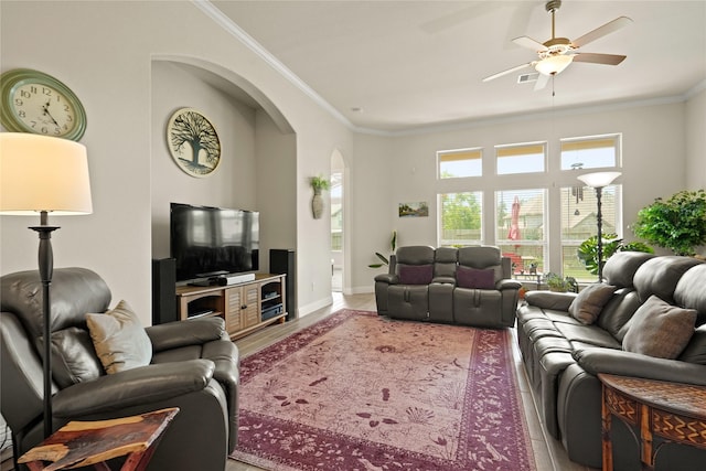 23440 Yaupon Hills Dr, New Caney, TX 77357 - living area featuring crown molding, arched walkways, wood finished floors, a ceiling fan, and baseboards