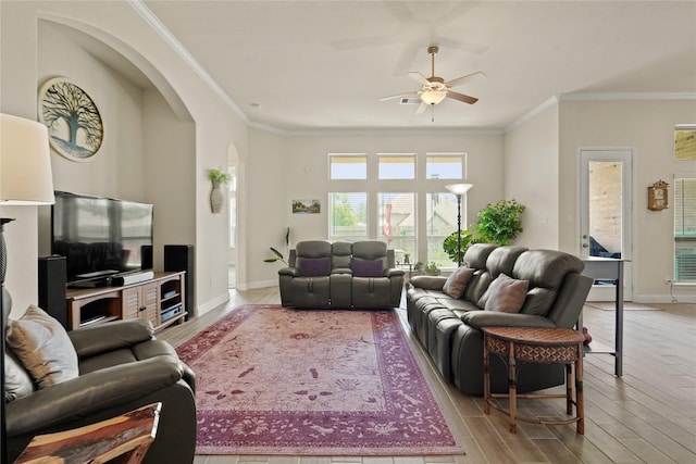 23440 Yaupon Hills Dr, New Caney, TX 77357 - living area with arched walkways, ceiling fan, ornamental molding, light wood finished floors, and baseboards