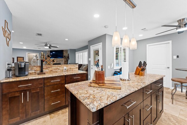 5511 Queensloch Dr, Houston, TX 77096 - kitchen featuring a ceiling fan, open floor plan, light stone counters, recessed lighting, and pendant lighting