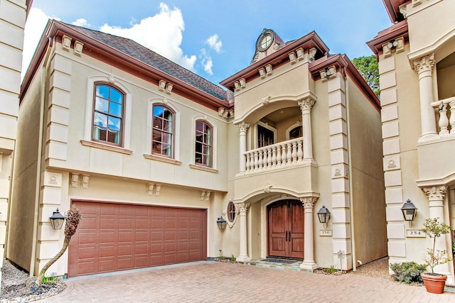 256 S Post Oak Ln, Houston, TX 77056 - view of front of house with a balcony, a garage, decorative driveway, and stucco siding