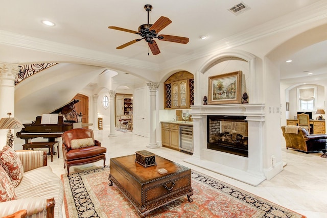 256 S Post Oak Ln, Houston, TX 77056 - living area featuring ornate columns, arched walkways, wine cooler, ceiling fan, and ornamental molding