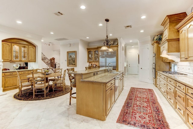256 S Post Oak Ln, Houston, TX 77056 - kitchen with a sink, appliances with stainless steel finishes, a breakfast bar area, glass insert cabinets, and ornamental molding