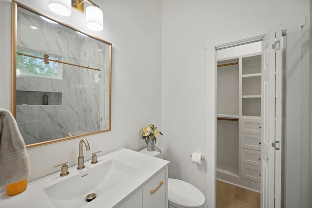 7321 Ponderosa Dr, Magnolia, TX 77354 - bathroom featuring a marble finish shower, vanity, wood finished floors, and toilet