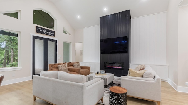 7321 Ponderosa Dr, Magnolia, TX 77354 - living area featuring light wood finished floors, high vaulted ceiling, a decorative wall, recessed lighting, and a fireplace