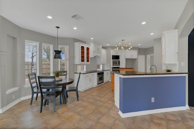 9619 Silver Birch Ct, Missouri City, TX 77459 - kitchen featuring stainless steel oven, a chandelier, a peninsula, white cabinetry, and recessed lighting