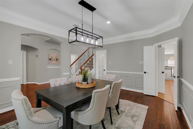 9619 Silver Birch Ct, Missouri City, TX 77459 - dining area featuring stairway, arched walkways, a wainscoted wall, dark wood finished floors, and a decorative wall
