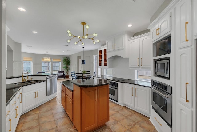 9619 Silver Birch Ct, Missouri City, TX 77459 - kitchen featuring stainless steel appliances, a sink, a chandelier, a kitchen island, and white cabinets