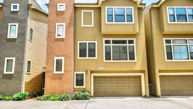 1609 W 24th St Unit B, Houston, TX 77008 - view of front facade featuring stucco siding, an attached garage, and driveway