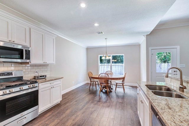 426 Pebble Dr, Dayton, TX 77535 - kitchen with stainless steel appliances, a sink, baseboards, dark wood finished floors, and crown molding