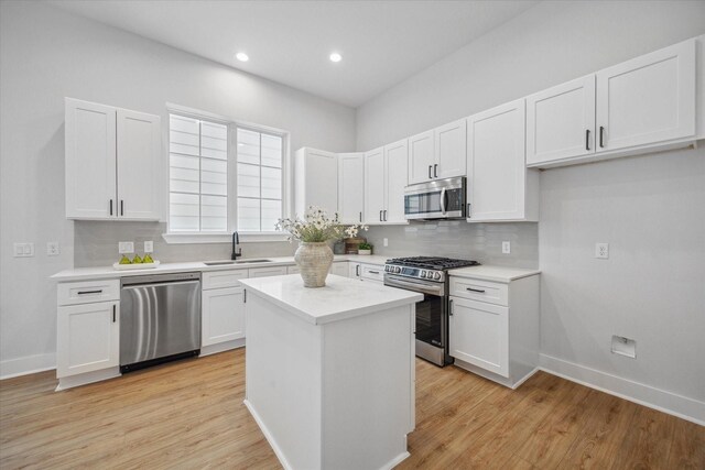 1037 17th St, Houston, TX 77008 - kitchen with stainless steel appliances, decorative backsplash, light countertops, white cabinetry, and a kitchen island