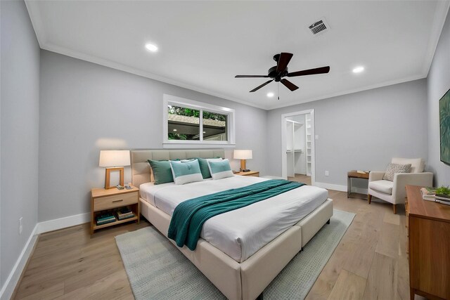 1122 Lehman St, Houston, TX 77018 - bedroom with a walk in closet, light wood-style floors, crown molding, recessed lighting, and baseboards