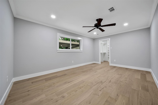 1122 Lehman St, Houston, TX 77018 - unfurnished bedroom featuring a walk in closet, crown molding, light wood-style floors, baseboards, and recessed lighting