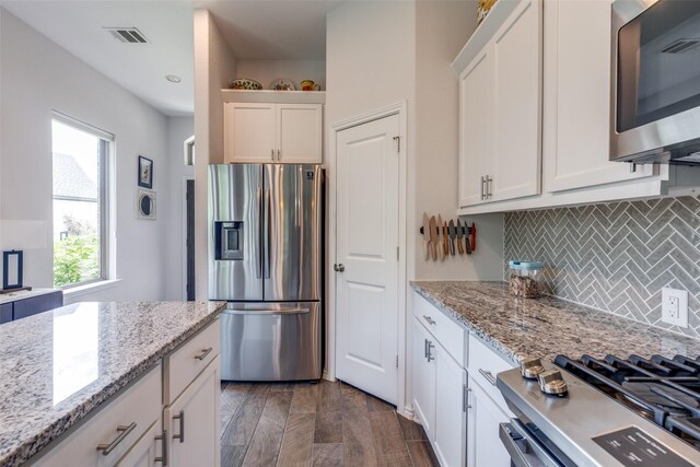 342 Topper Pines Dr, Montgomery, TX 77316 - kitchen with stainless steel appliances, decorative backsplash, white cabinetry, light stone counters, and dark wood finished floors
