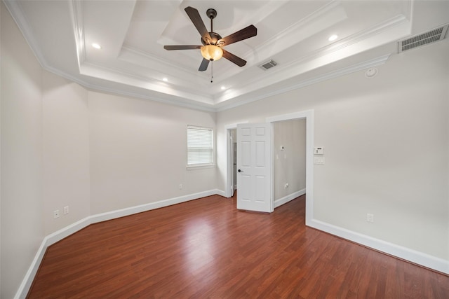 unfurnished room with a raised ceiling, crown molding, a ceiling fan, wood finished floors, and baseboards