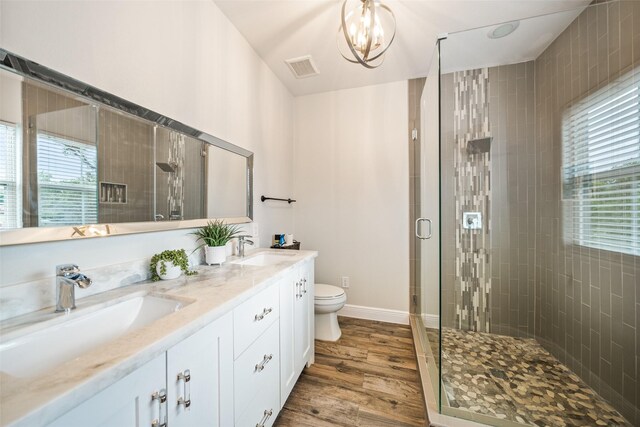 bathroom with a shower stall, toilet, and wood finished floors