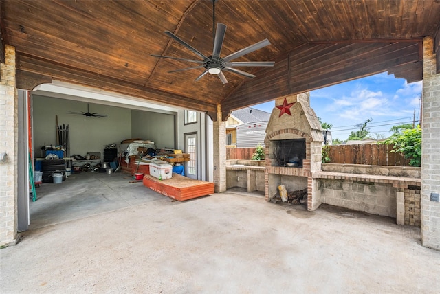 view of patio / terrace with a ceiling fan, a garage, and fence