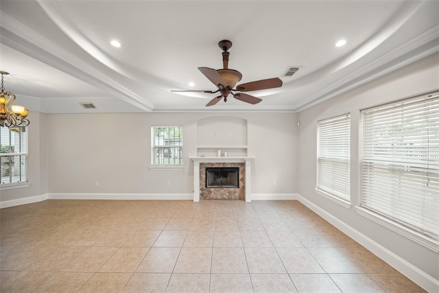 unfurnished living room with a raised ceiling, light tile patterned floors, recessed lighting, a high end fireplace, and ceiling fan