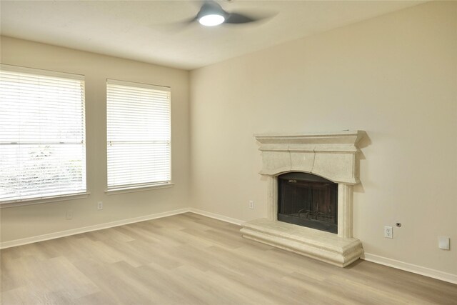 23902 Spring Way Dr, Spring, TX 77373 - unfurnished living room featuring a ceiling fan, wood finished floors, baseboards, a fireplace with raised hearth, and healthy amount of natural light