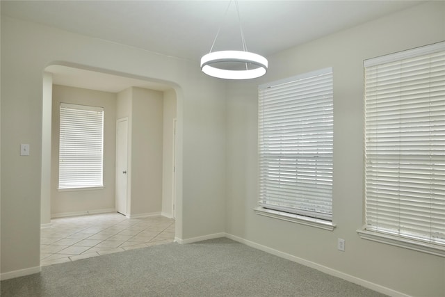 23902 Spring Way Dr, Spring, TX 77373 - tiled empty room featuring arched walkways, carpet flooring, and baseboards