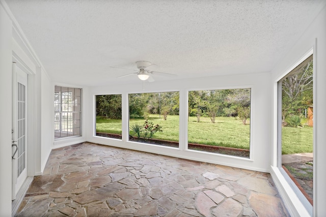 115 Old Caney Rd, Wharton, TX 77488 - unfurnished sunroom featuring stone floors, a textured ceiling, and baseboards