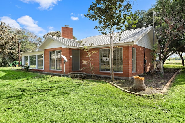 115 Old Caney Rd, Wharton, TX 77488 - back of house featuring a chimney, a yard, and metal roof