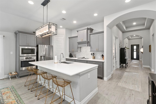 kitchen with stainless steel appliances, gray cabinetry, a sink, and recessed lighting