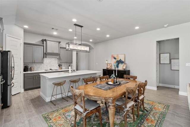 dining space featuring light wood-type flooring, recessed lighting, and baseboards