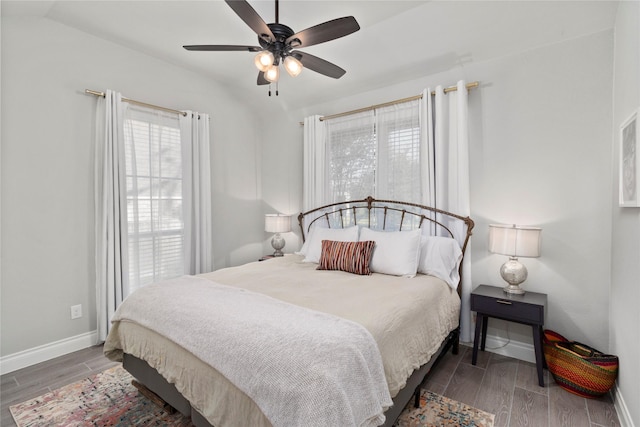 bedroom with baseboards, wood finished floors, a ceiling fan, and vaulted ceiling