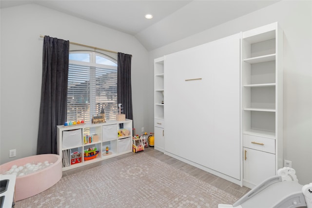recreation room featuring vaulted ceiling and wood finished floors