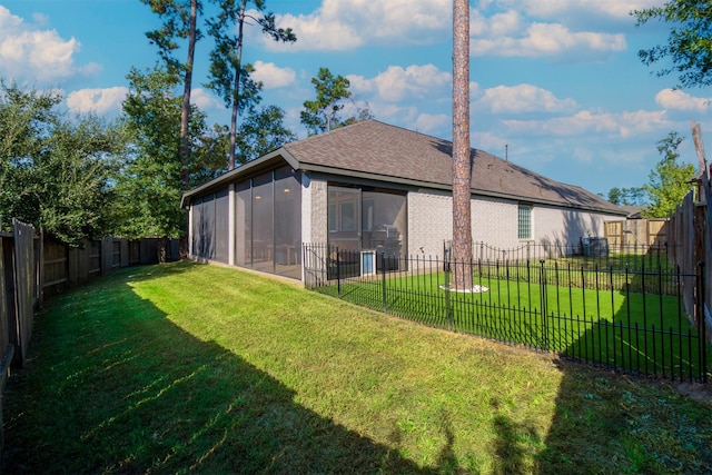back of house with a sunroom and roof with shingles