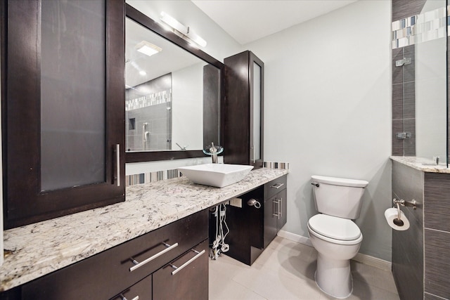 6549 Bayou Glen Rd, Houston, TX 77057 - bathroom featuring toilet, vanity, baseboards, tiled shower, and tile patterned flooring