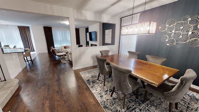dining area with wood finished floors, baseboards, and a chandelier