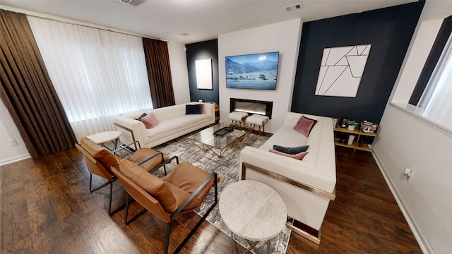 living area featuring hardwood / wood-style floors, baseboards, and healthy amount of natural light