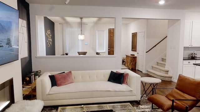 living area with stairway and wood finished floors