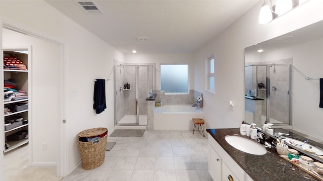 full bath with a shower stall, vanity, tile patterned flooring, a bath, and a spacious closet
