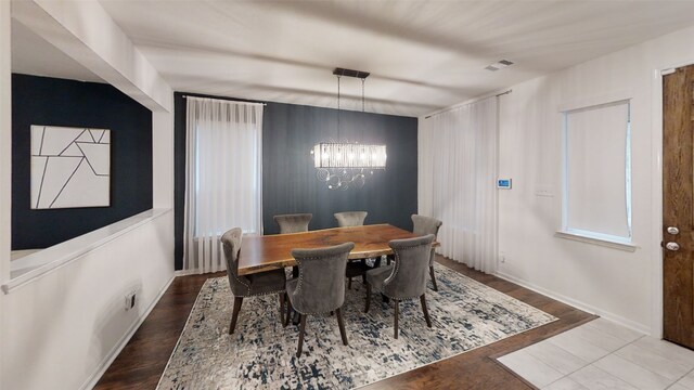 dining space featuring a chandelier and baseboards