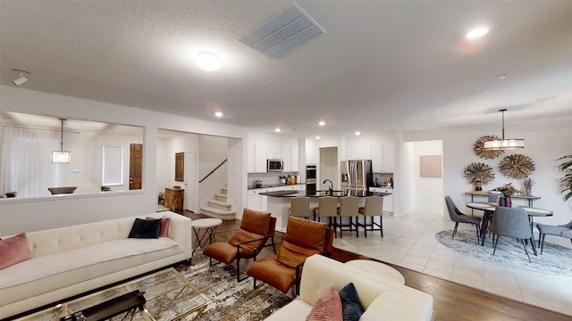 living area with stairs, recessed lighting, and light wood-style floors