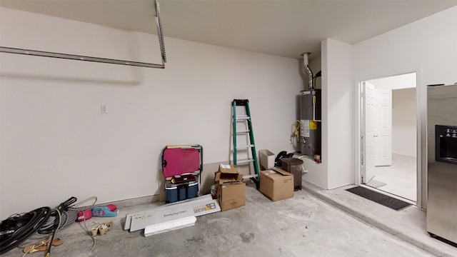garage featuring gas water heater and stainless steel refrigerator with ice dispenser