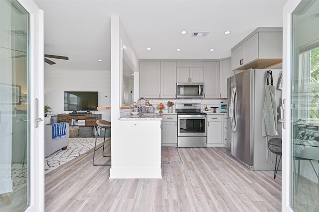 16716 Tahiti Way, Galveston, TX 77554 - kitchen with appliances with stainless steel finishes, gray cabinets, light wood-type flooring, a ceiling fan, and recessed lighting